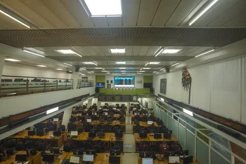 Yukarıdan görülen, sıra sıra bilgisayar masaları ve fiyat ekranı bulunan bir borsa işlem salonu