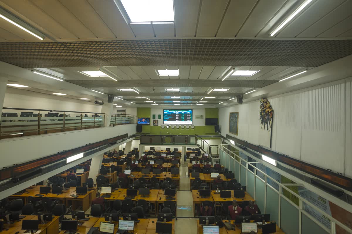 Yukarıdan görülen, sıra sıra bilgisayar masaları ve fiyat ekranı bulunan bir borsa işlem salonu