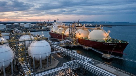 LNG terminaline yanaşmış tanker; rıhtımda küresel gaz depolama tankları